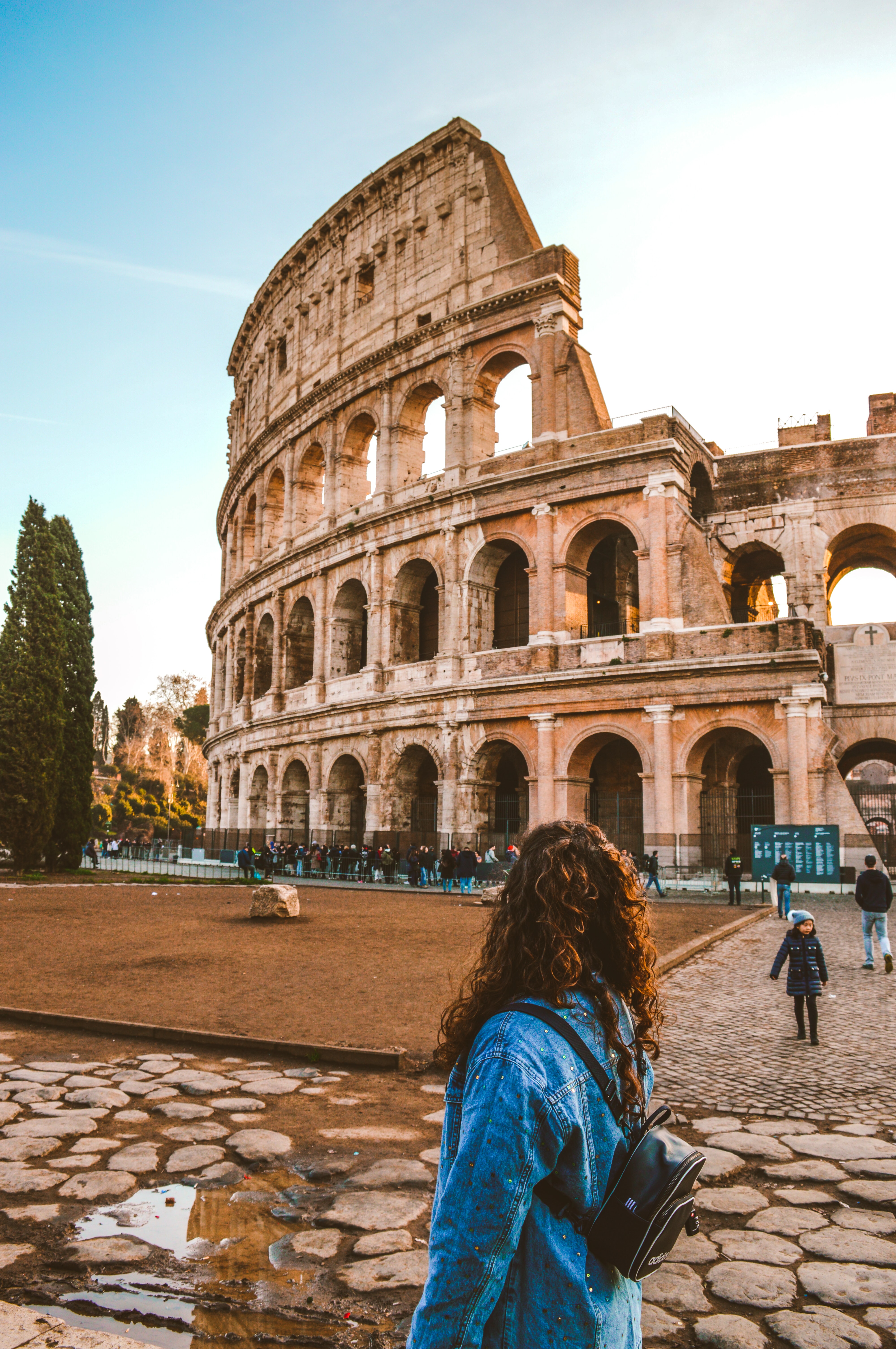 a woman looks at the colosseum